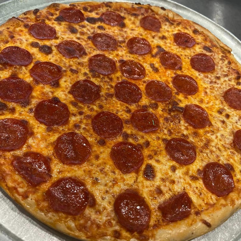 A freshly baked, round pepperoni pizza from American Pie of Rome, with melted cheese and a golden crust.