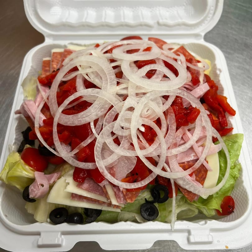 A large antipasto salad from American Pie of Rome, with lettuce, meats, cheeses, onions, and peppers.